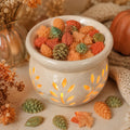 Harvest Market leaves and pinecones wax melts in a cozy autumn wax warmer setting