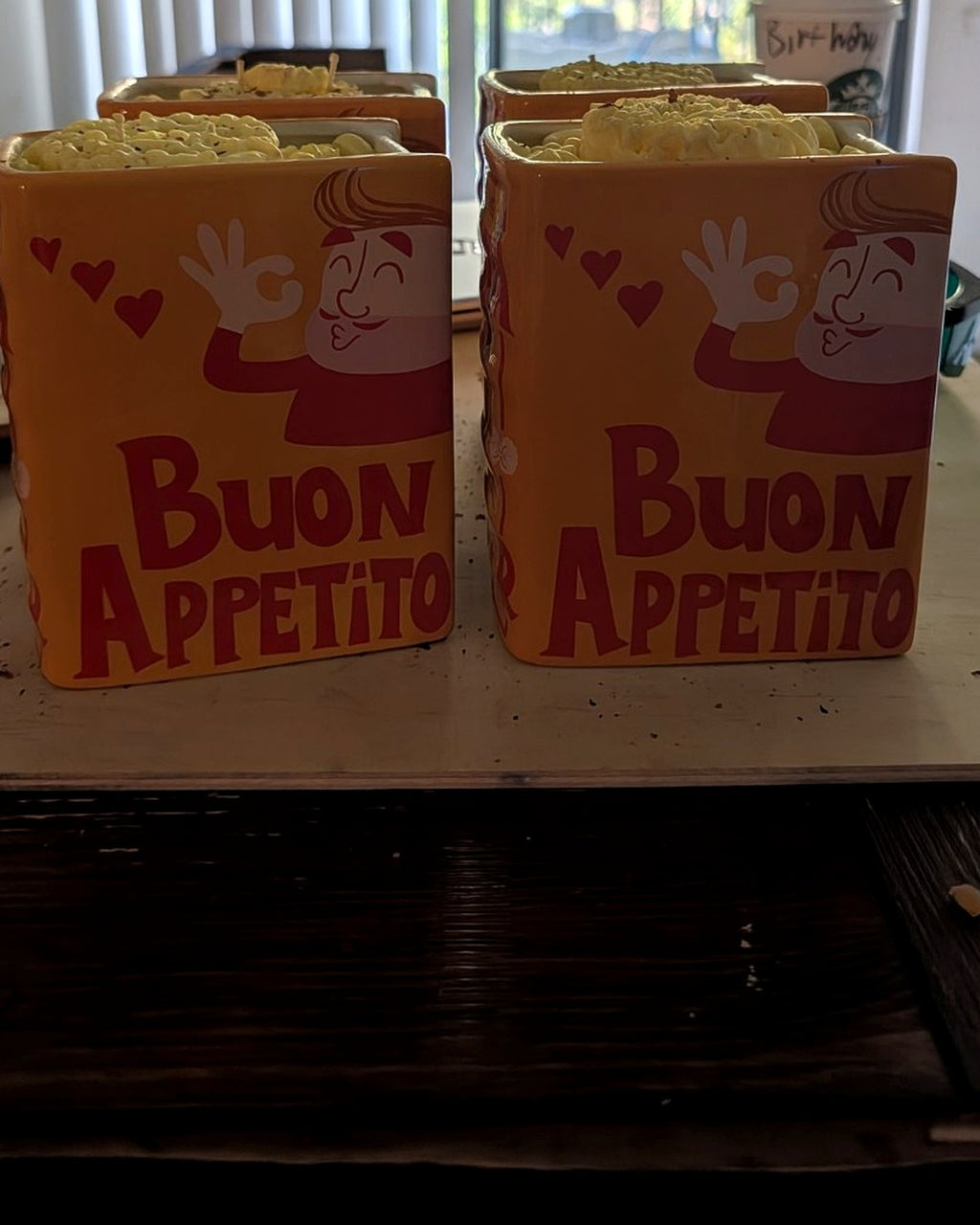 Four finished I Love Pasta candles in orange ceramic pasta book vessels